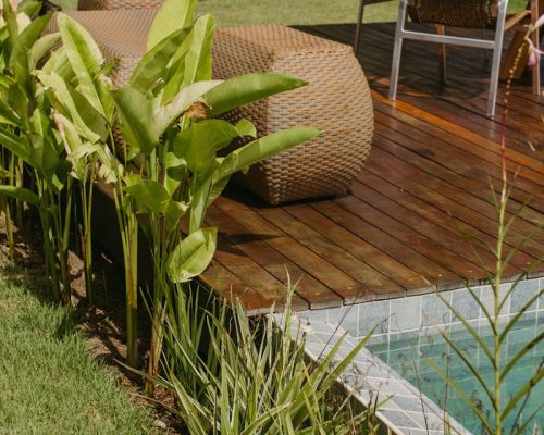 Relaxing outdoor deck with poolside seating and tropical plants in Bahia, Brazil.